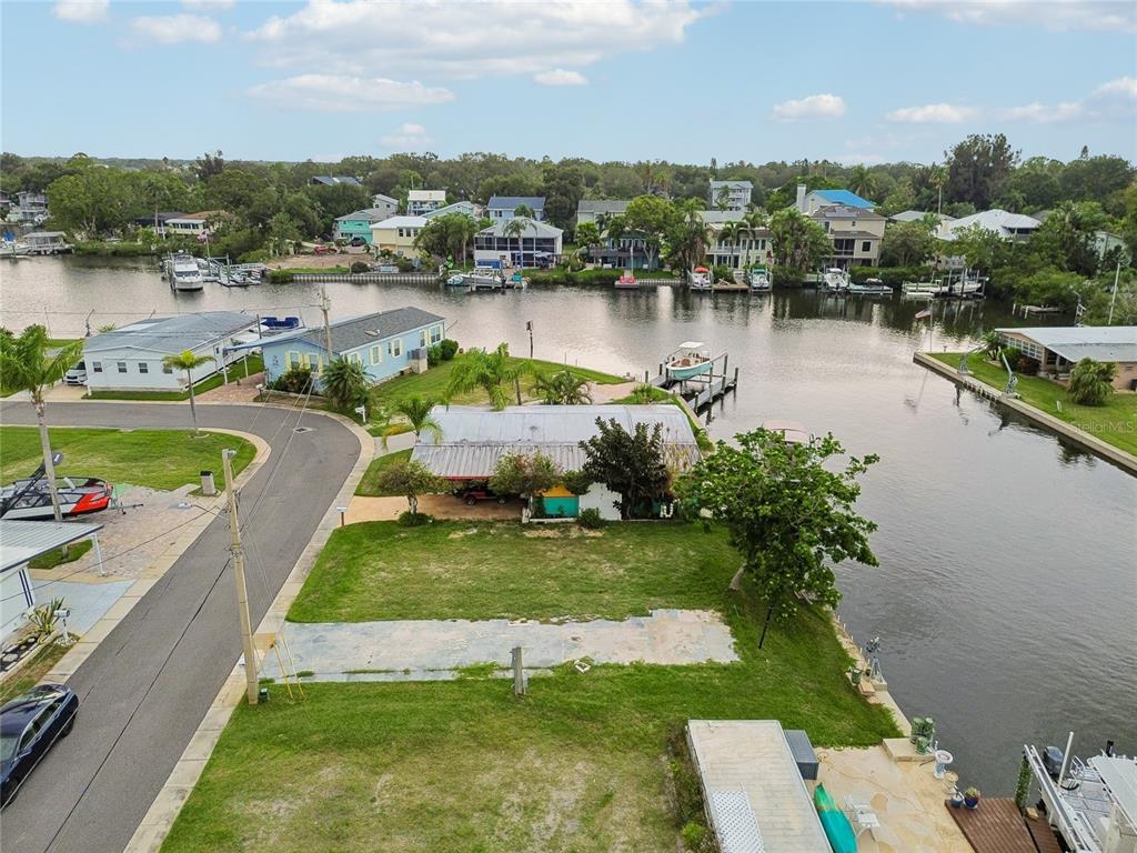 An aerial view shows a waterfront lot with a small structure and a boat dock — 102 SCHOONER DRIVE UNIT 102, PALM HARBOR, FL