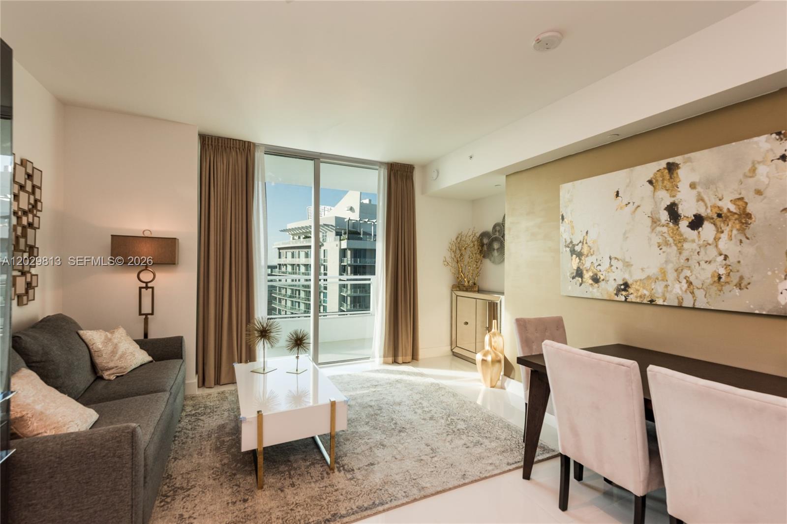 A living and dining area features a grey sofa, white coffee table, and balcony view — 1080 Brickell Ave # 4105, Miami FL 33131, MIAMI, FL