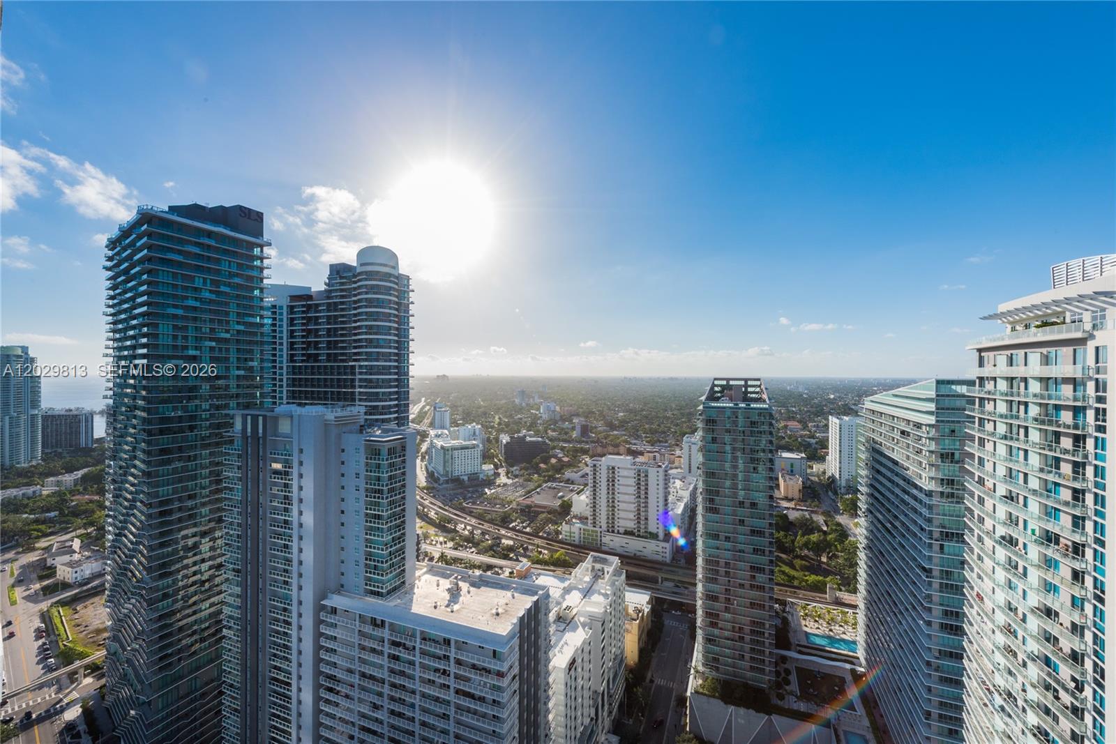 An elevated view shows several modern high-rise buildings in a dense urban landscape under sunlight — 1080 Brickell Ave # 4105, Miami FL 33131, MIAMI, FL