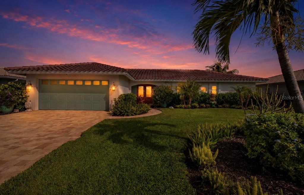 A single-story house with a green garage door and tiled roof at sunset — 2011 MICHIGAN AVENUE NE, ST PETERSBURG, FL