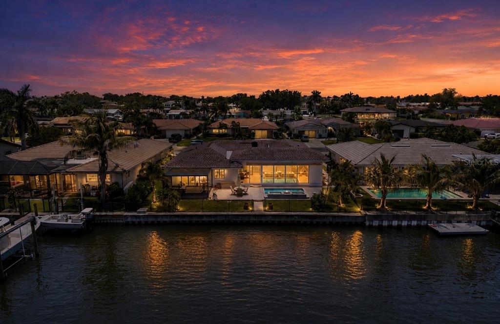 An aerial view of a waterfront house with a pool at sunset — 2011 MICHIGAN AVENUE NE, ST PETERSBURG, FL