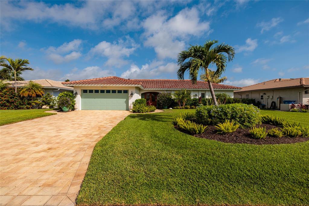 A single-story house with a tiled roof, a light green garage door, and a paved driveway — 2011 MICHIGAN AVENUE NE, ST PETERSBURG, FL