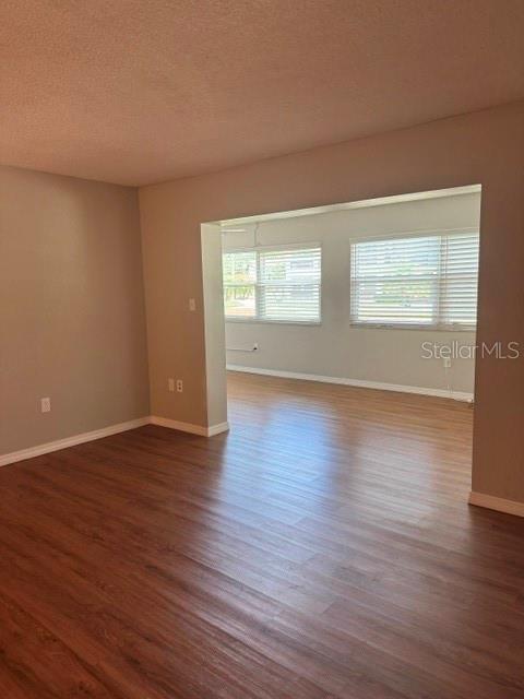 An interior view shows a living area with wood-look flooring and a large wall opening — 4743 JASPER DRIVE UNIT 101, NEW PORT RICHEY, FL