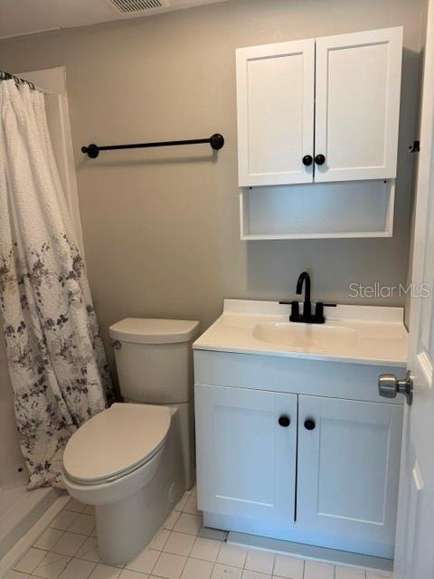 A bathroom features a white vanity with a black faucet, a toilet, and wall-mounted cabinets — 4743 JASPER DRIVE UNIT 101, NEW PORT RICHEY, FL