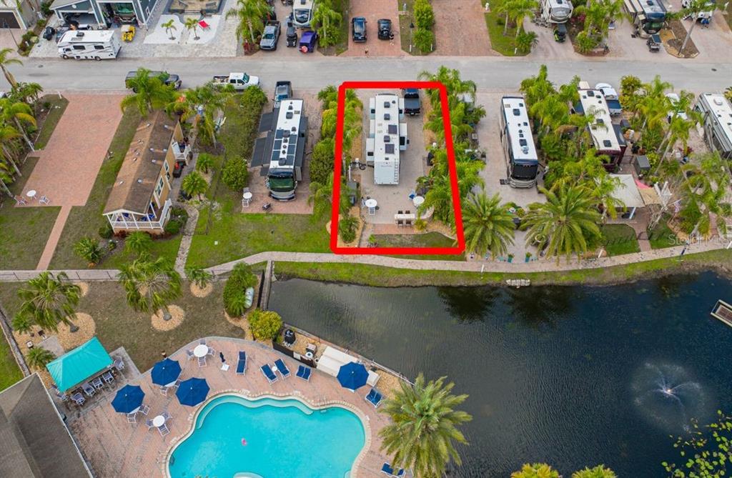 An aerial view shows a paved RV lot with a trailer and patio near a pool — 6770 AMANDA VISTA CIRCLE, LAND O LAKES, FL