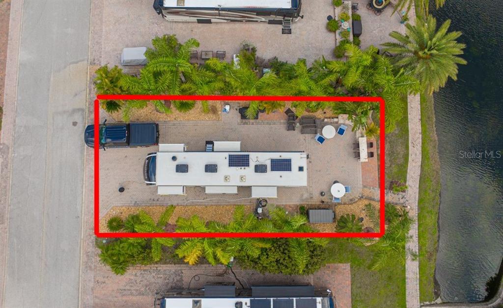An aerial view shows an RV parked on a paved lot with outdoor furniture and landscaping — 6770 AMANDA VISTA CIRCLE, LAND O LAKES, FL