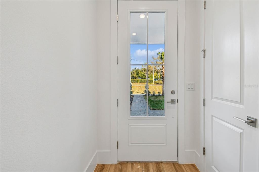 A white front door with a glass pane opens to a view of a walkway — 221 PASQUALA UNIT 18, OVIEDO, FL