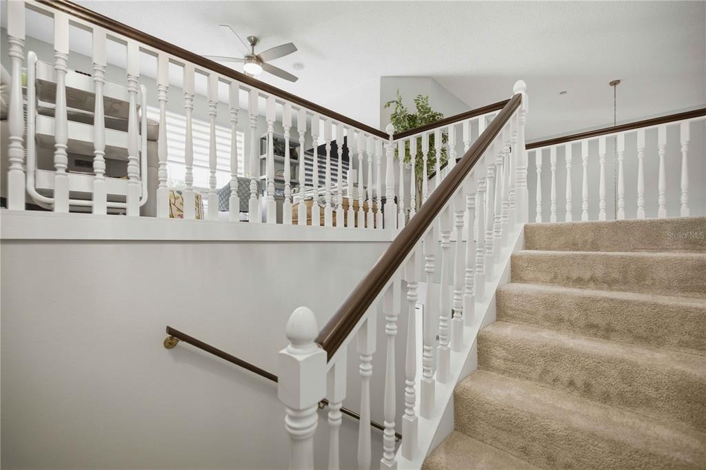 A carpeted staircase leads up to a landing with white railings and a wooden handrail — 1118 AVENIDA DE LAS CASAS, LADY LAKE, FL