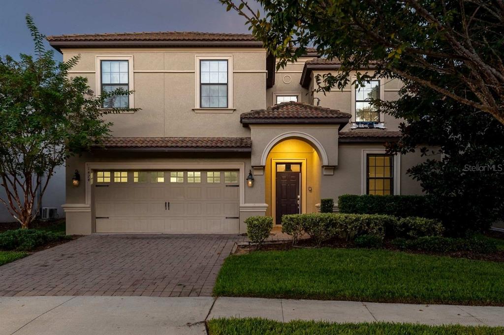 A two-story stucco house with a tiled roof, a two-car garage, and a covered entryway — 1474 ROLLING FAIRWAY DRIVE, DAVENPORT, FL