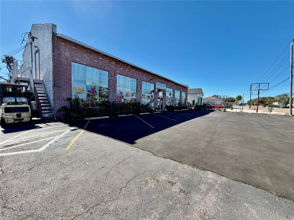 A brick commercial building with large windows and a parking lot under a clear sky — 4022 54TH AVENUE N, ST PETERSBURG, FL
