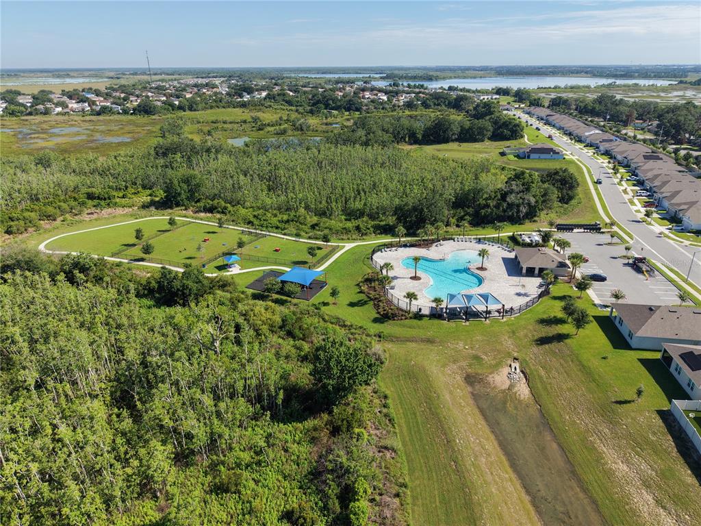 An aerial view shows a community swimming pool, a fenced dog park, and nearby houses — 4027 ALISSA LANE, HAINES CITY, FL