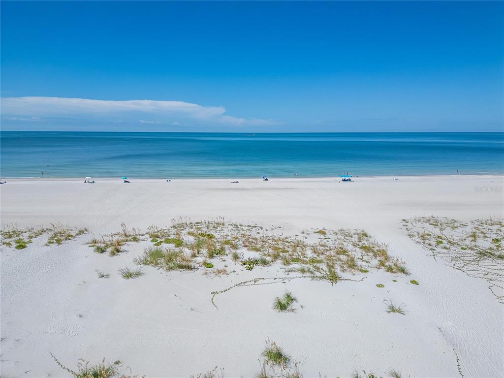 An aerial view of a white sand beach with sparse vegetation and the ocean — 10178 GULF BOULEVARD, TREASURE ISLAND, FL