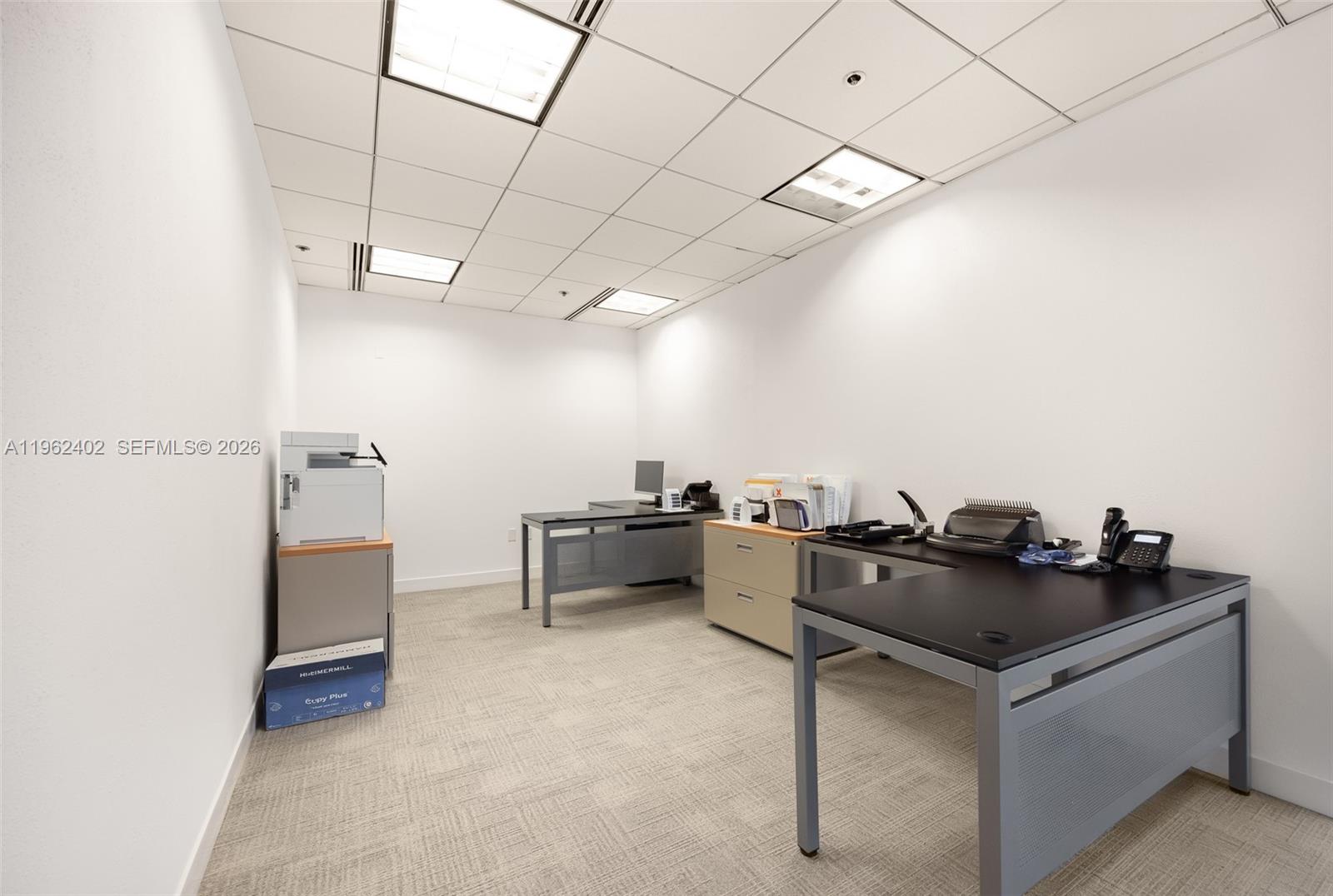 A small office space features two desks, a filing cabinet, and a printer on carpeted flooring — 1001 Brickell Bay Dr # 2112, Miami FL 33131, MIAMI, FL