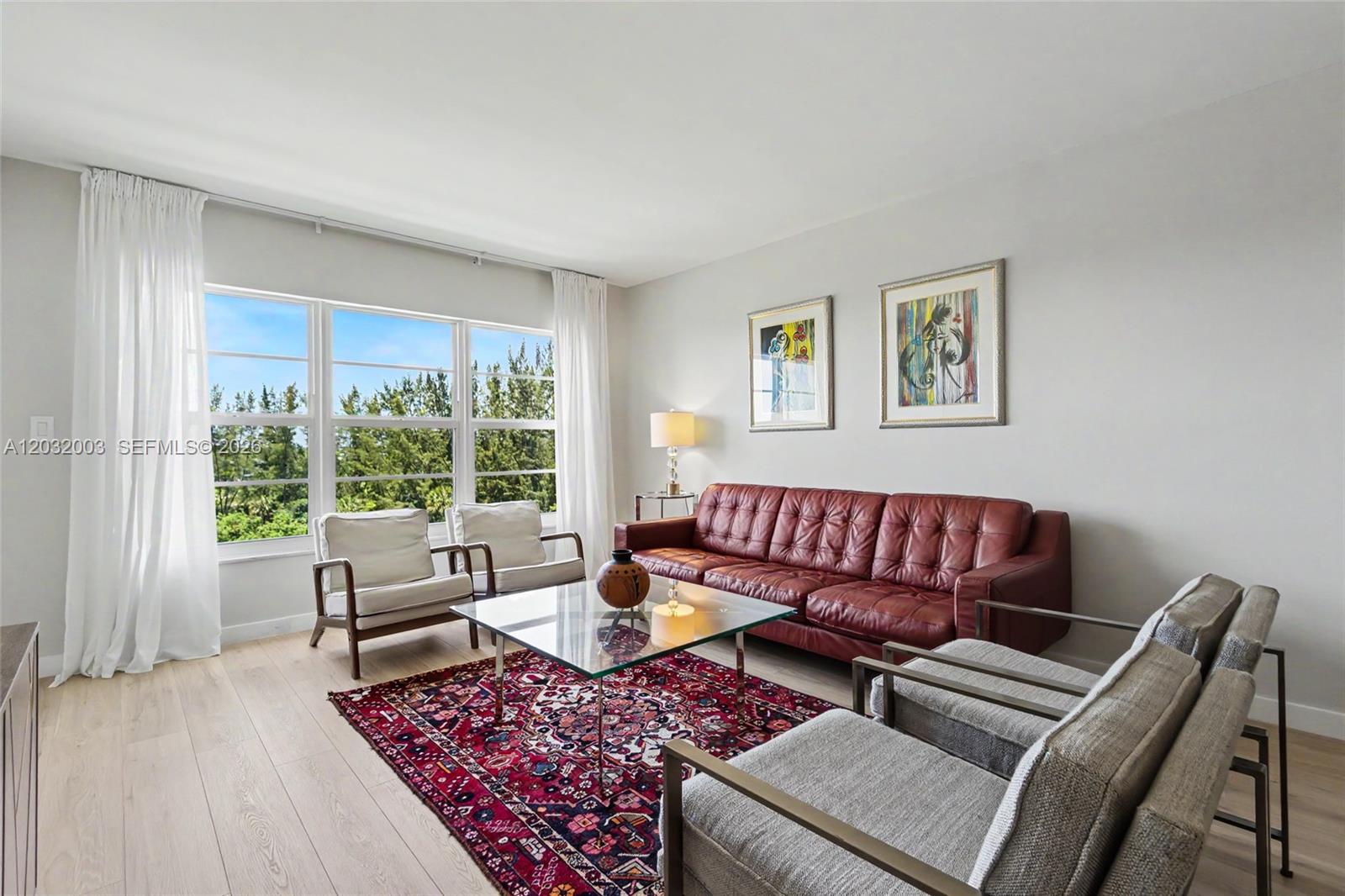 A living room features a red leather sofa, gray armchairs, and a patterned area rug — 3150 N Palm Aire Dr # 705, Pompano Beach FL 33069, POMPANO BEACH, FL