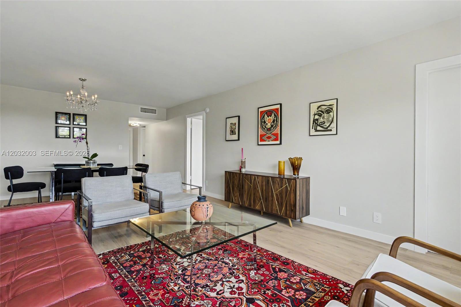 A living room features a red sofa, patterned rug, glass coffee table, and wooden sideboard — 3150 N Palm Aire Dr # 705, Pompano Beach FL 33069, POMPANO BEACH, FL