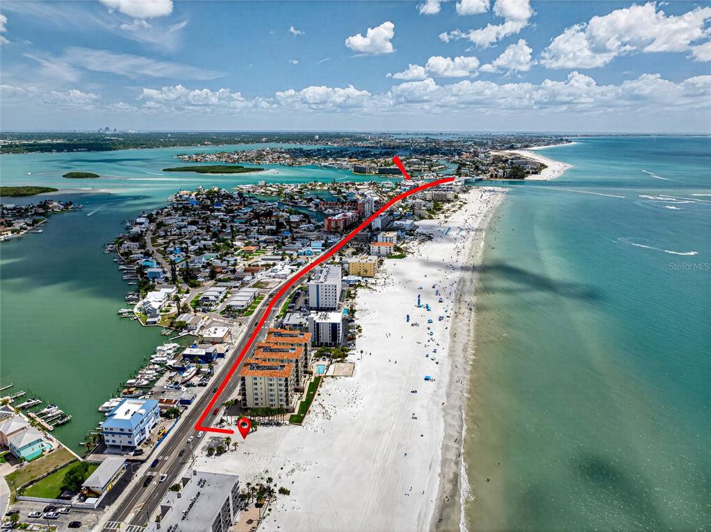 An aerial view shows a beachside road and buildings along the coastline — 13642 GULF BOULEVARD, MADEIRA BEACH, FL