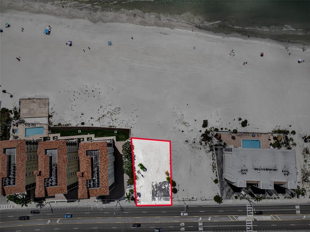 Aerial view of a vacant, rectangular beachfront lot situated between two multi-story buildings — 13642 GULF BOULEVARD, MADEIRA BEACH, FL