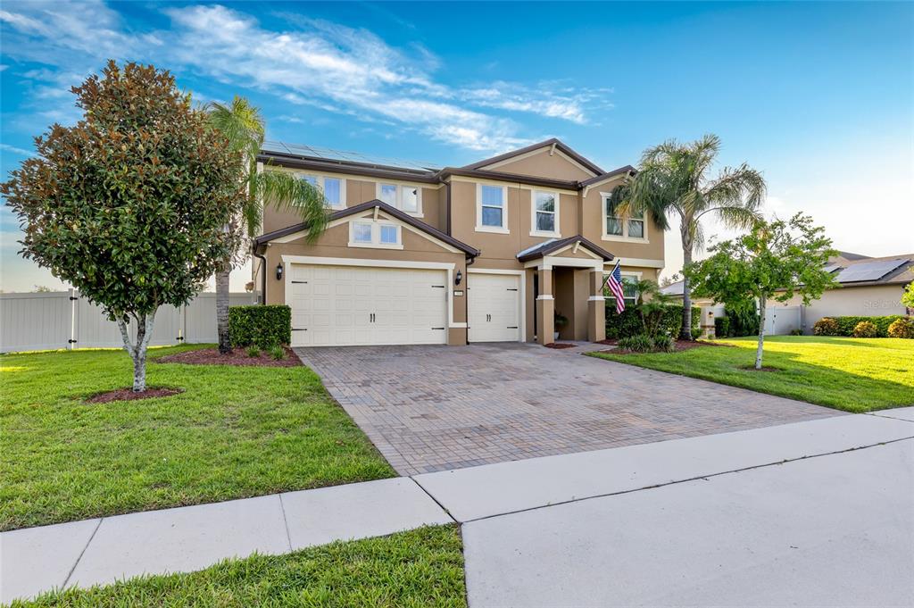 A two-story suburban house with a paved driveway, a three-car garage, and palm trees — 3344 KAYAK WAY, ORLANDO, FL