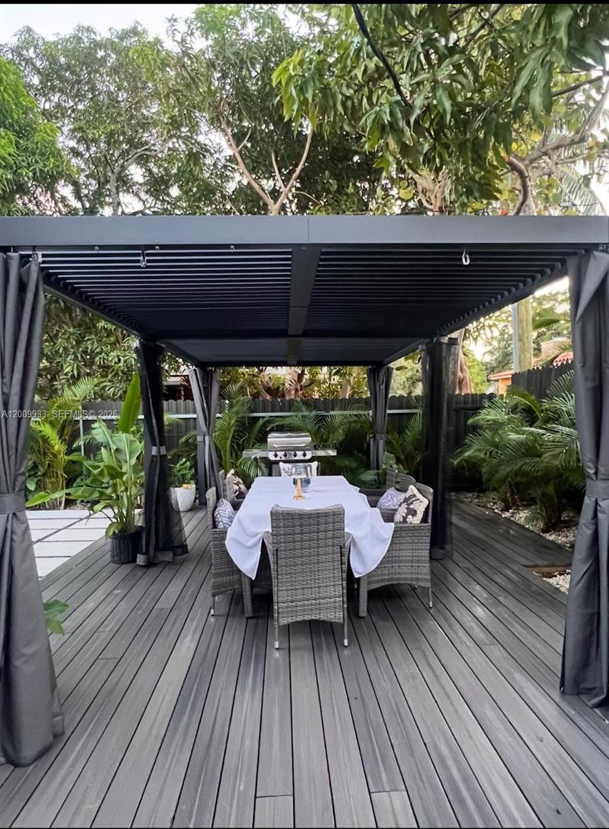 A gray outdoor deck features a dining set under a modern louvered pergola — 1030 NE 83rd St # 0, Miami FL 33138, MIAMI, FL