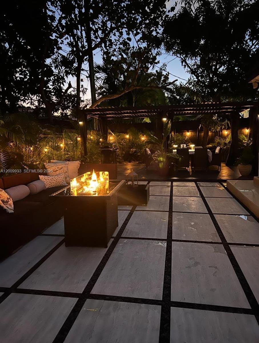 A patio features a fire pit, outdoor seating, and a dining area under a pergola — 1030 NE 83rd St # 0, Miami FL 33138, MIAMI, FL