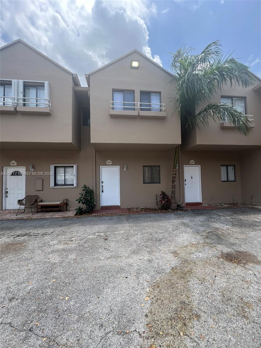 The exterior view shows three adjacent townhouse units with white doors and brown stucco walls — 5694 W 25th Ct # 5694, Hialeah FL 33016, HIALEAH, FL