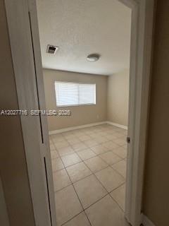 A view through a doorway into an empty bedroom with beige tile flooring and blinds — 5694 W 25th Ct # 5694, Hialeah FL 33016, HIALEAH, FL