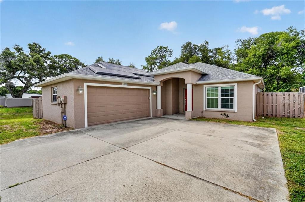 A single-story house with a tan stucco exterior, a two-car garage, and a concrete driveway — 1881 SUMMER WALK CIRCLE, SARASOTA, FL