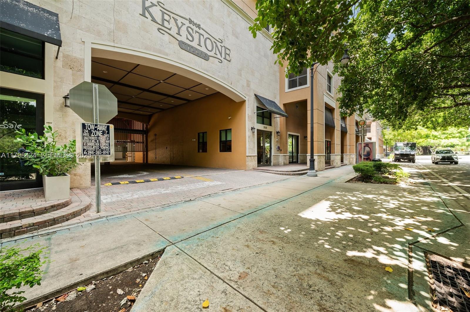 The exterior of a multi-story building features a covered driveway entrance and a sidewalk — 3530 SW 22nd St # 614, Miami FL 33145, MIAMI, FL