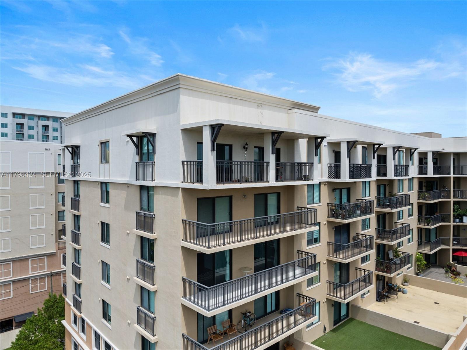 An exterior view of a multi-story apartment building featuring balconies with dark metal railings — 3530 SW 22nd St # 614, Miami FL 33145, MIAMI, FL