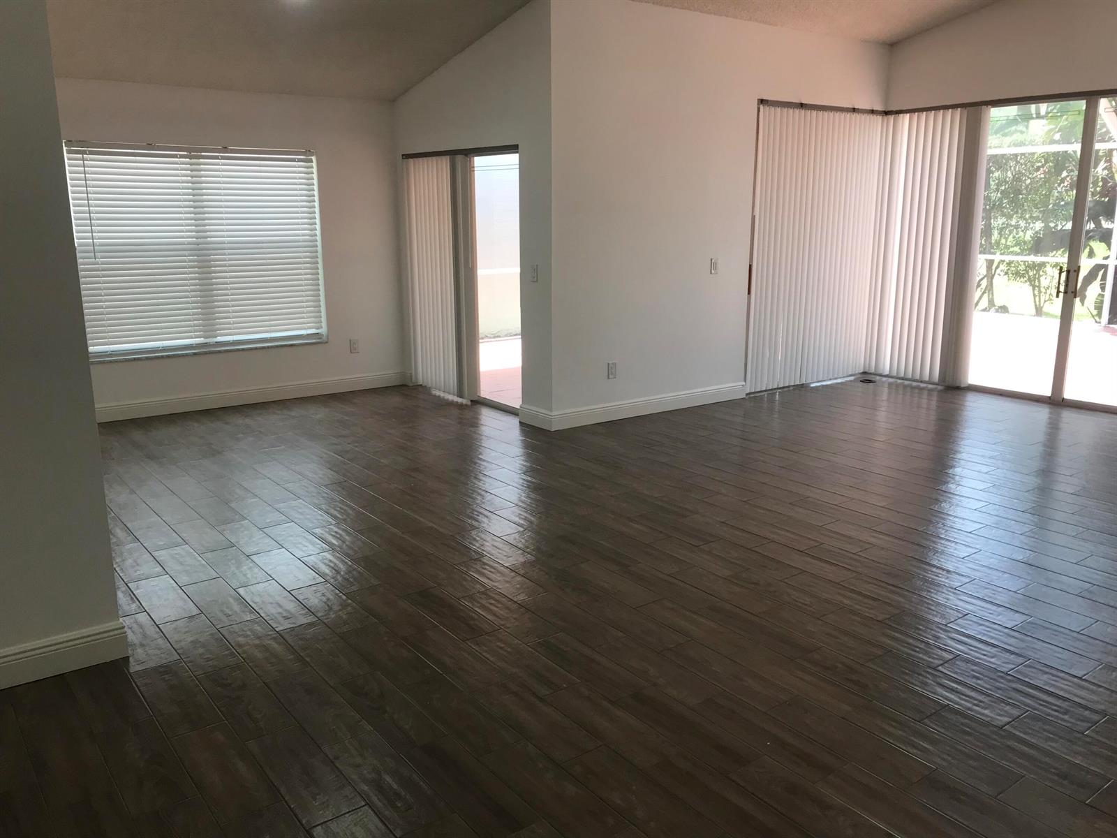 A kitchen features white cabinets, stainless steel appliances, a sink, and wood-look flooring — 7296 Via Palomar, Boca Raton FL 33433, BOCA RATON, FL