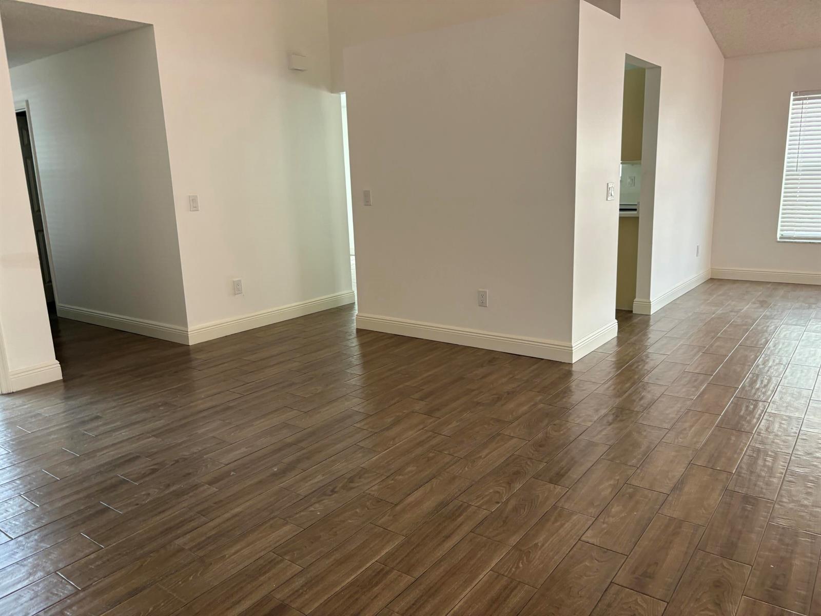 A kitchen features white cabinets, a stainless steel dishwasher, a sink, and wood-look flooring — 7296 Via Palomar, Boca Raton FL 33433, BOCA RATON, FL