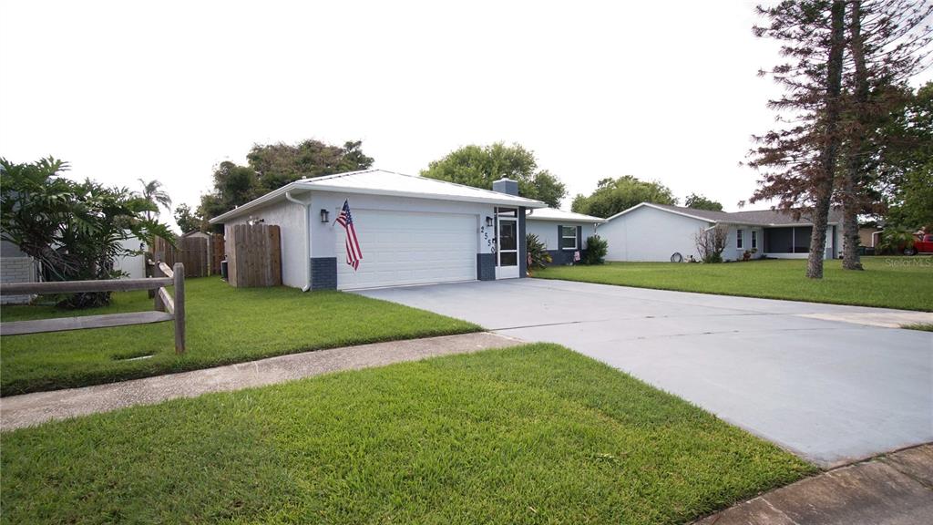 A single-story house with a white garage door, a concrete driveway, and a grassy lawn — 2550 FULTON COURT, MELBOURNE, FL