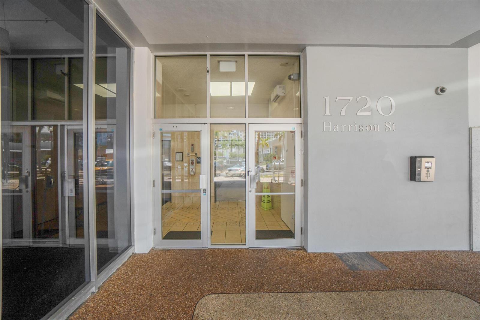 The exterior entrance features glass double doors with a transom window and a concrete wall — 1720 E Harrison Street # A, Hollywood FL 33020, HOLLYWOOD, FL