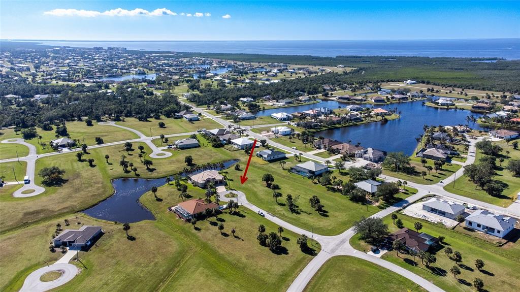 An aerial view shows a residential neighborhood with houses, ponds, and a red arrow — 16407 RABAT WAY, PUNTA GORDA, FL
