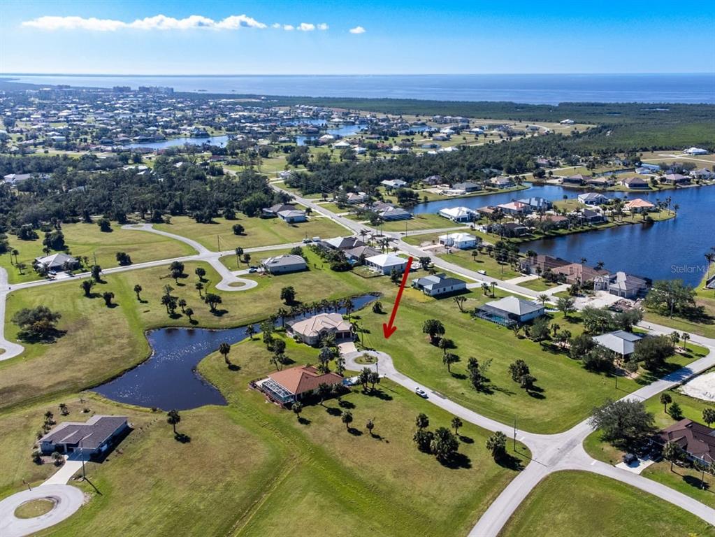 An aerial view shows a vacant lot with a circular driveway in a residential neighborhood — 16407 RABAT WAY, PUNTA GORDA, FL