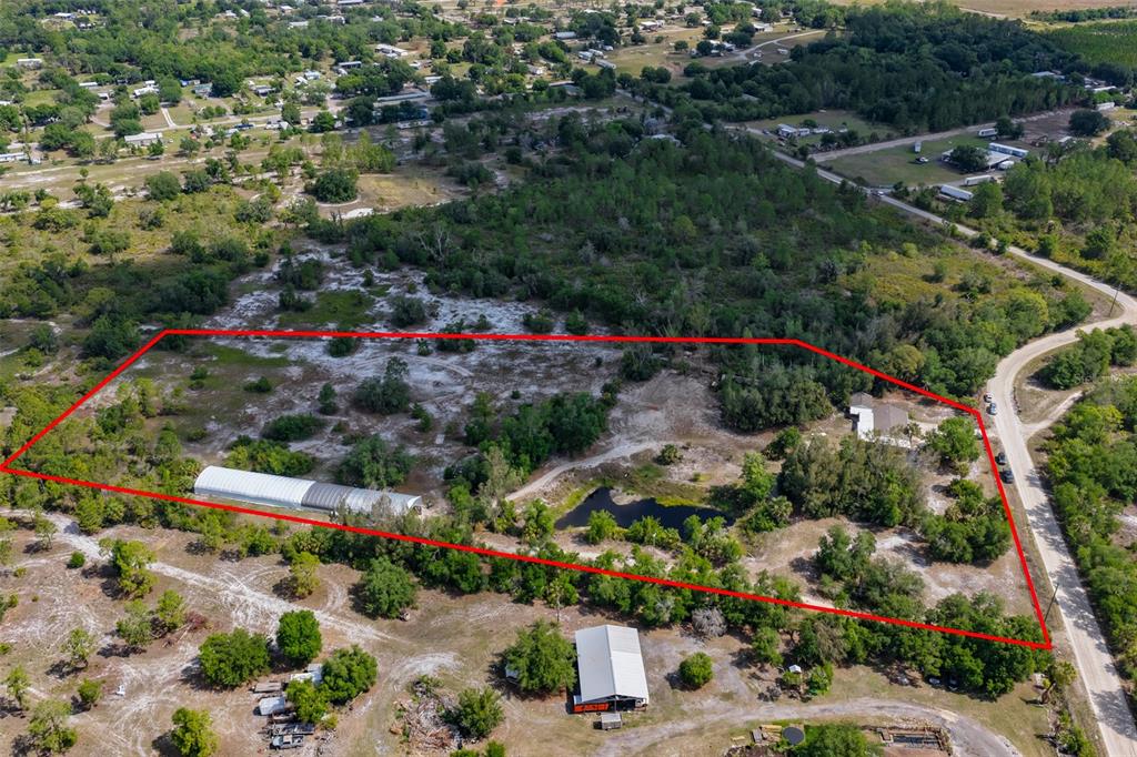 An aerial view shows a large, rural property outlined in red with a pond and structures — 14451 HIGHLAND ROAD, WIMAUMA, FL