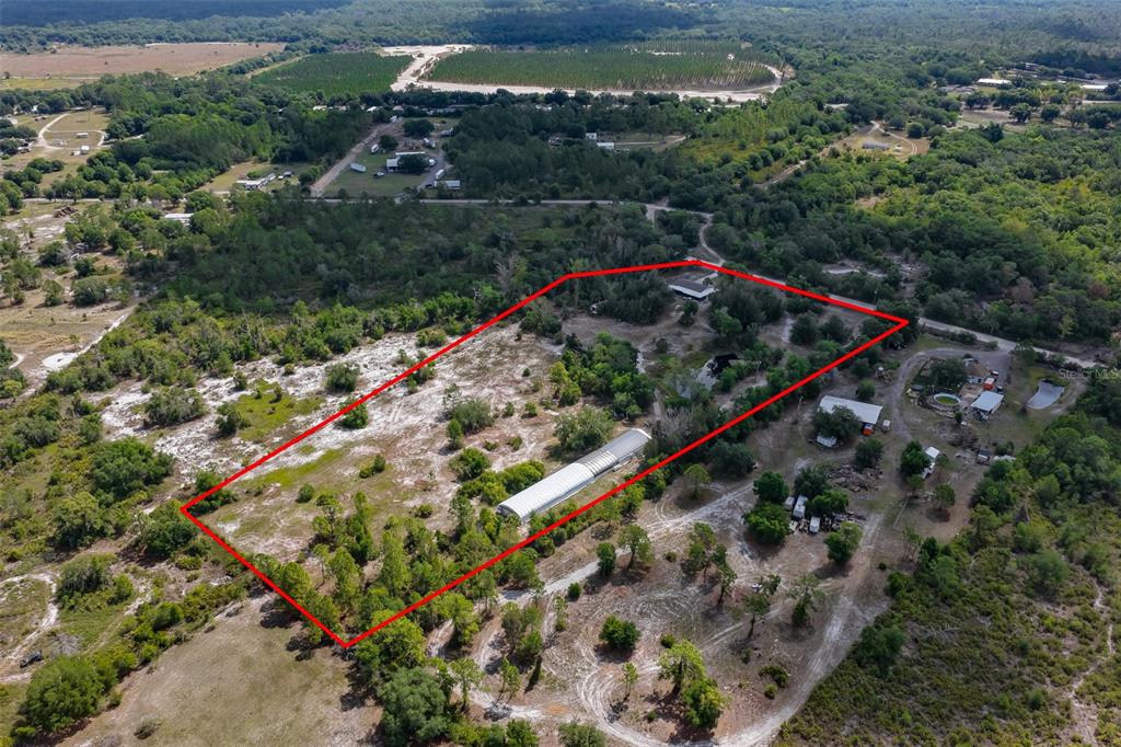 An aerial view shows a rectangular property outlined in red containing trees and structures — 14451 HIGHLAND ROAD, WIMAUMA, FL