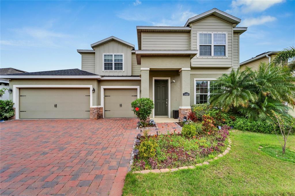 A two-story house with a brick paver driveway, a three-car garage, and landscaping — 11628 LAKE LUCAYA DRIVE, RIVERVIEW, FL