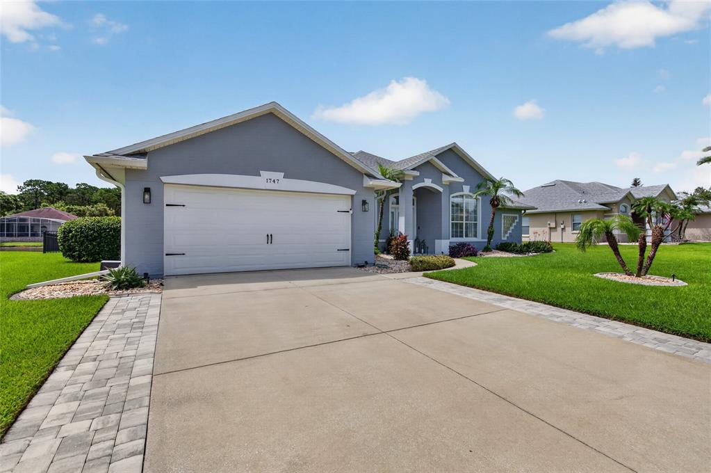 A gray single-story house with a two-car garage and a paved driveway — 1747 TRIBUTORY LANE, PORT ORANGE, FL