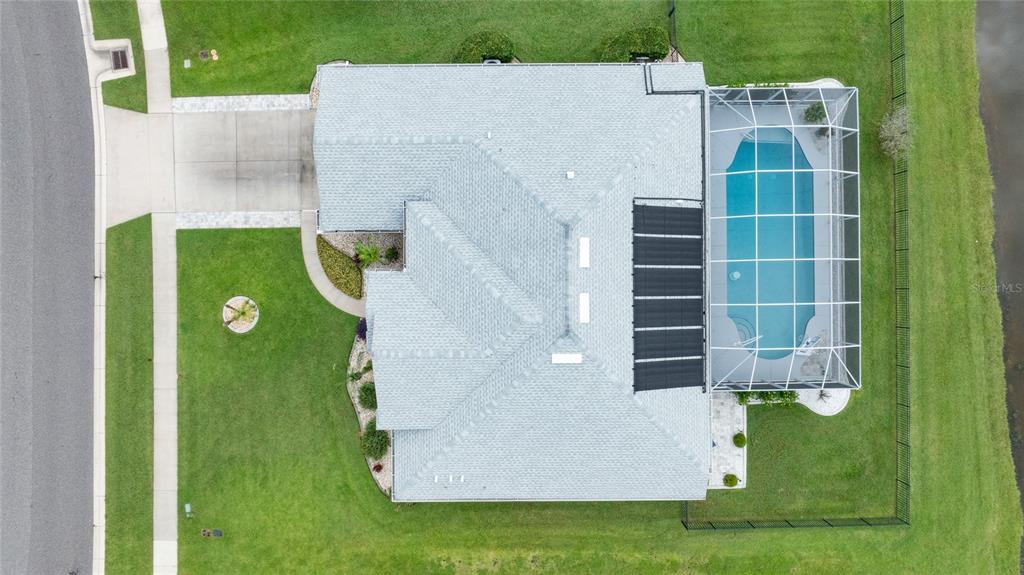 An aerial view shows a house with a gray roof, a pool cage, and a driveway — 1747 TRIBUTORY LANE, PORT ORANGE, FL