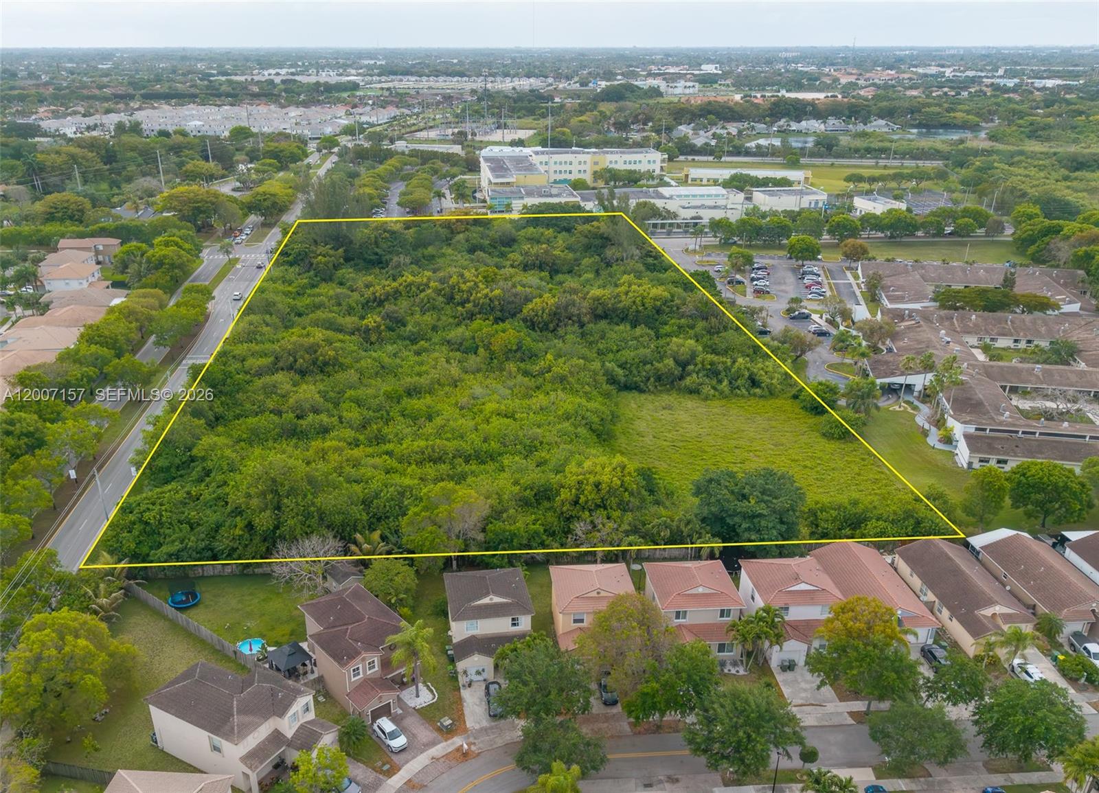 An aerial view shows a large, undeveloped rectangular plot of land surrounded by residential housing — S Canal Dr, Homestead FL 33035, HOMESTEAD, FL