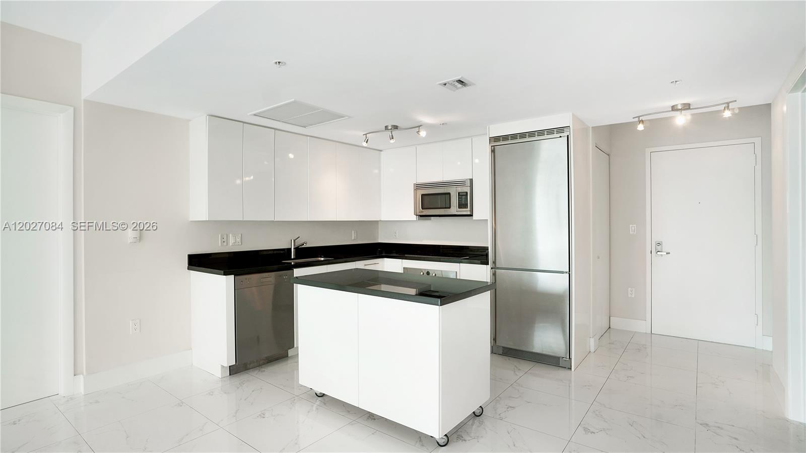 A modern kitchen features white cabinets, black countertops, stainless steel appliances, and a mobile island — 92 SW 3rd St # 1803, Miami FL 33130, MIAMI, FL