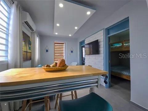 A dining area features a wooden table, a fruit bowl, and a doorway to a bedroom — 173 CALLE FLORIDA, LUQUILLO, PR