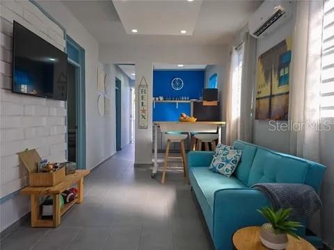 A living room features a blue sofa, a wooden bench, and a dining area beyond — 173 CALLE FLORIDA, LUQUILLO, PR
