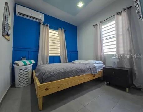 A bedroom features a single bed with a gray quilt against a bright blue wall — 173 CALLE FLORIDA, LUQUILLO, PR