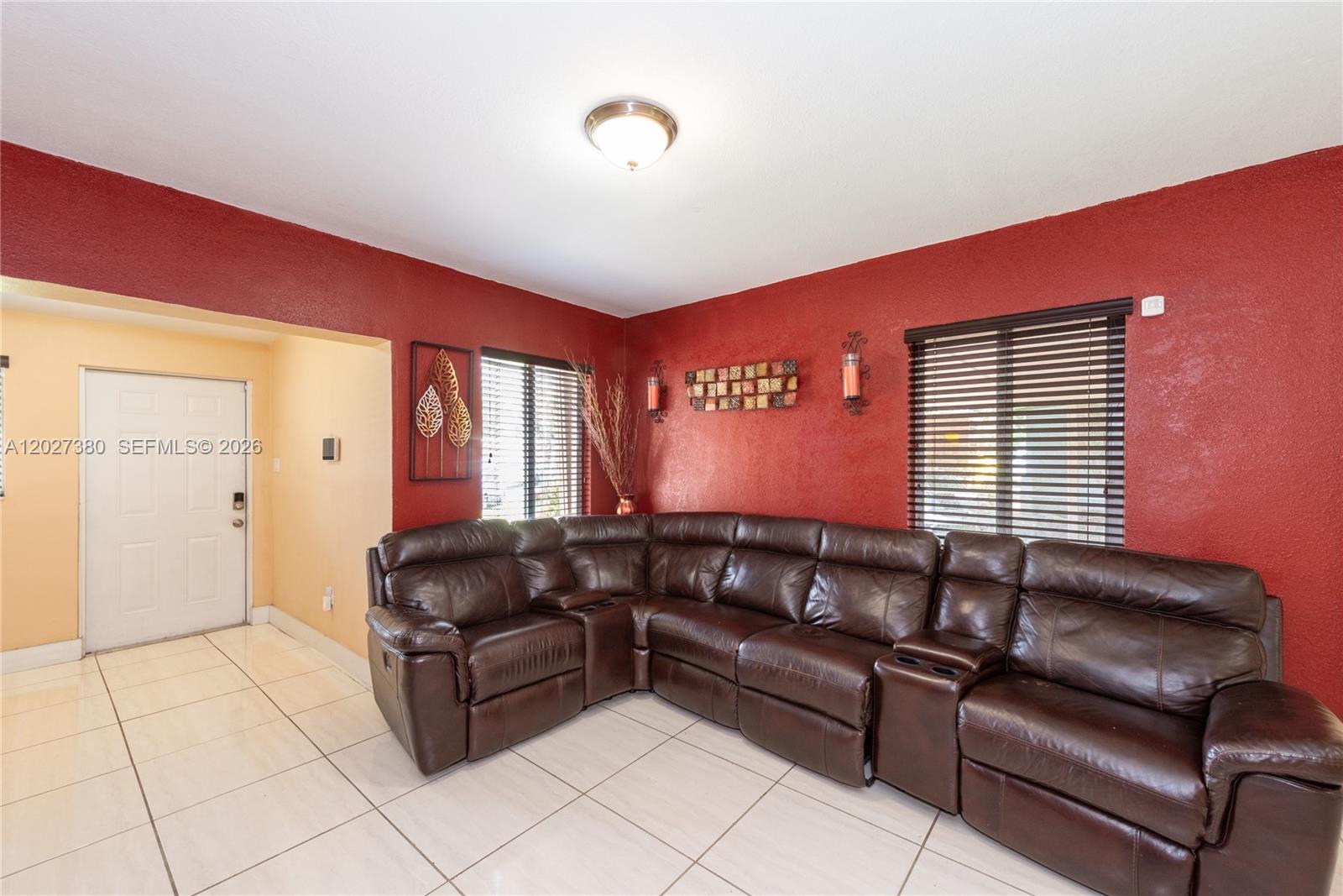 A living room features red walls, white tile flooring, and a large brown leather sectional — 12741 Wood St, Miami FL 33167, MIAMI, FL