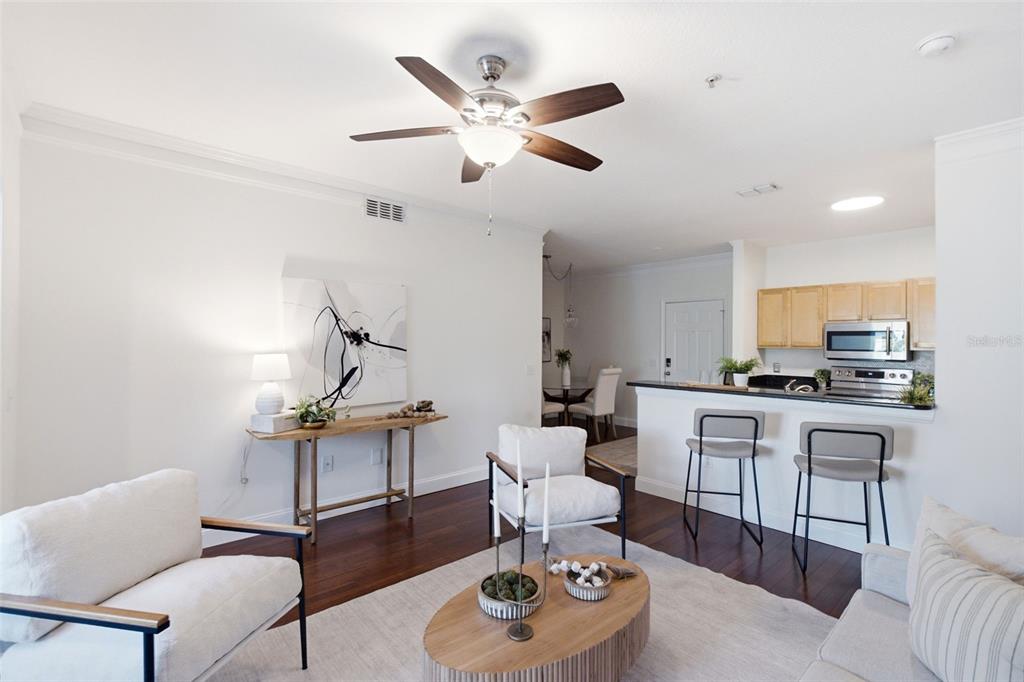 A living room features white walls, dark wood floors, a ceiling fan, and modern furniture — 4207 S DALE MABRY HIGHWAY UNIT 2301, TAMPA, FL