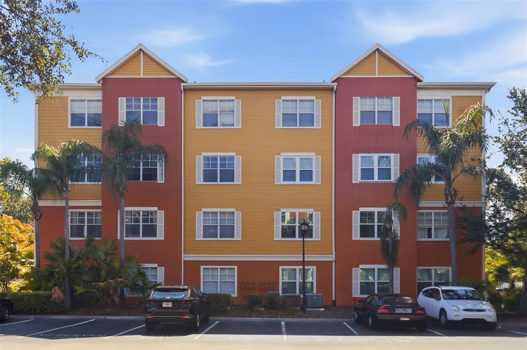 A living room with white chairs, a wooden coffee table, and an open kitchen area — 4207 S DALE MABRY HIGHWAY UNIT 2301, TAMPA, FL