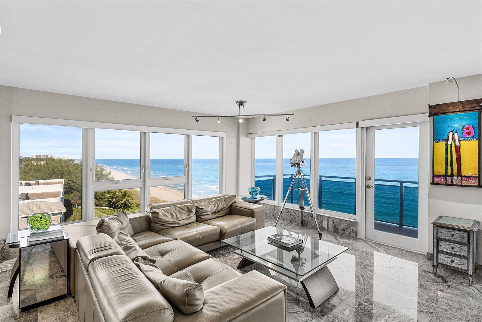 A living room with a leather sectional, glass coffee table, marble floors, and ocean views — 2066 N Ocean Boulevard, Boca Raton FL 33431, BOCA RATON, FL