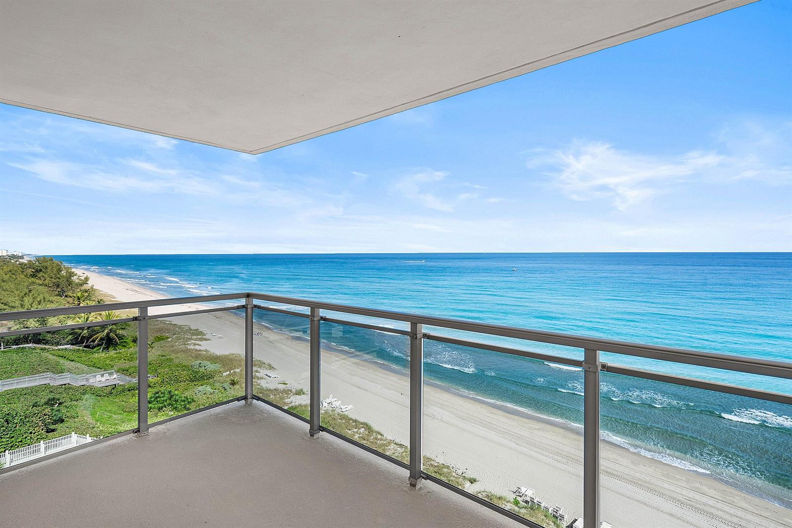 A balcony with a glass railing overlooks a sandy beach and the ocean — 2066 N Ocean Boulevard, Boca Raton FL 33431, BOCA RATON, FL